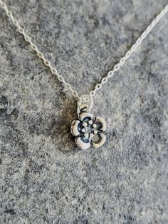 "Tiny sterling silver plum blossom necklace. Our tiny plum blossom necklace is solid sterling silver and has a 3 dimensional flower with an antiqued finish. It hangs from a small but strong sterling silver chain with a sterling spring clasp. The flower measures 8mm across and shown here on a 17\" chain. *If you are unsure of the length you need, or would like to wear this item at different lengths, we now offer an adjustable length option! You can add an adjustable end to your necklace using thi Dainty Silver Charm Necklace With Flower Pendant, Dainty Sterling Silver Flower Pendant Charm Necklace, Delicate Silver Charm Necklace With Flower, Delicate Silver Flower-shaped Charm Necklace, Delicate Silver Flower Shape Charm Necklace, Nickel-free Silver Flower Charm Necklace, Nickel-free Sterling Silver Flower Necklace, Delicate Silver Flower Charm Necklace, Sterling Silver Flower Charm Pendant Necklace