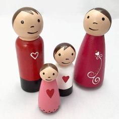 three wooden figurines with hearts on them