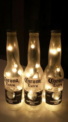 three bottles with lights on them sitting on a table