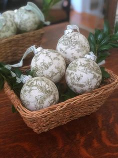 four white ornaments in a wicker basket on a table