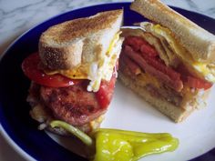 the sandwich is cut in half and ready to be eaten on the plate next to jalapenos