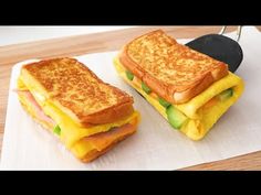 two grilled sandwiches sitting on top of a cutting board