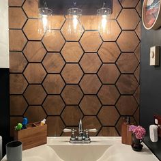 a bathroom sink sitting under a mirror next to a wall with lights on top of it