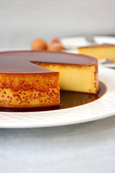 a piece of cheesecake on a plate with chocolate sauce and nuts in the background