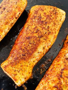 three pieces of cooked fish sitting on top of a pan