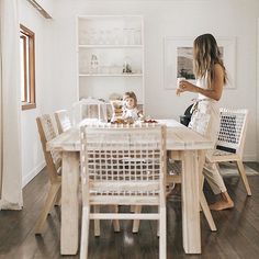 a woman sitting at a table with a child