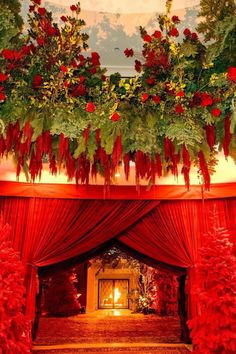 the entrance to a lavishly decorated room with red drapes and poinsettis