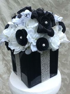 a black and white wedding cake with flowers on top