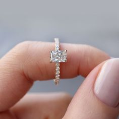 a person holding an engagement ring in their hand with the diamond set on it's side