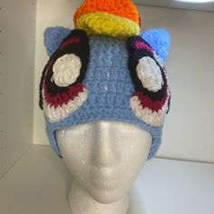 a crocheted hat with ears and eyes on top of a mannequin head