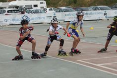 three children on roller skates playing with balls