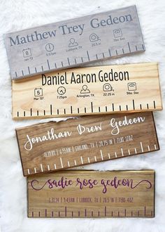 three wooden rulers with names on them sitting on a white furnishing area next to each other