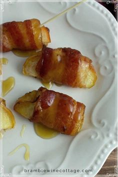 bacon wrapped potatoes on a white plate with honey syrup drizzled over them