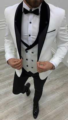 a man wearing a white tuxedo and black bow tie