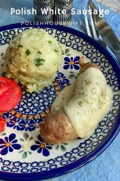 a blue and white plate topped with meat, mashed potatoes and tomato wedges