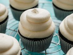 cupcakes with white frosting sitting on a cooling rack