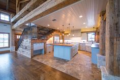 a large open floor plan with stairs leading up to the kitchen