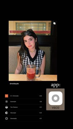 a woman sitting at a table with a drink in front of her and an app on the screen