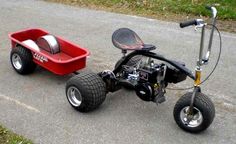 a small red cart sitting on the side of a road next to a scooter