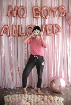 a woman taking a photo in front of balloons