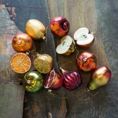 an assortment of christmas ornaments on a wooden table with some string attached to the top