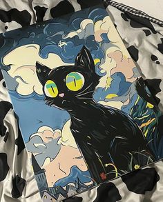 a black cat with yellow eyes sitting on top of a bed next to a blanket