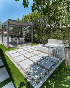 an outdoor living area with white furniture and grass