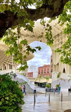 people are walking around in the rain under an umbrella covered building with stairs and trees