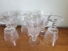 six clear glass decanters on a wooden table