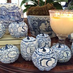 several blue and white vases sitting on top of a table next to a candle