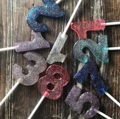 glitter number candles sitting on top of a wooden table