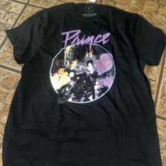 This Stylish Prince Purple Rain Shirt Is A Must-Have For Any Fan. It's A Size Large And Comes Brand New With Tags (Nwt). The Shirt Features A Classic Design Paying Homage To The Iconic Album 'Purple Rain,' Making It Perfect For Concerts, Casual Outings, Or Simply Expressing Your Love For Prince. Made From High-Quality Materials, It Offers Both Comfort And Durability. Don't Miss Out On This Unique Piece Of Music History! Purple Rain Shirt, Prince Purple, Prince Purple Rain, Music Tees, Music History, Purple Rain, Fit N Flare Dress, Concert Outfit, Fit & Flare