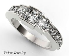 a diamond ring with three princess cut diamonds on the sides and an inscription that reads, vidar jewelry