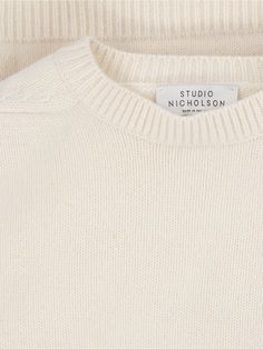 Studio Nicholson 'Hemyl' basic sweater in cream wool with crew neck, dropped shoulders, ribbed trims, straight hem. Composition: 100% Lamb Wool Classic White Sweater With Ribbed Neckline, Cream Ribbed Crew Neck Sweater, Cream Crew Sweater With Ribbed Cuffs, Classic Relaxed Fit Winter White Sweater, Classic Winter White Relaxed Fit Sweater, Classic White Relaxed Fit Sweater, Classic Off-white Relaxed Fit Sweater, Classic Cream Crew Neck Sweater, Classic Winter White Sweater With Ribbed Cuffs