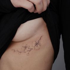 a close up of a person's stomach with flowers on the side and behind her