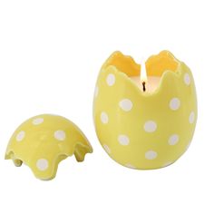 a yellow polka dot candle holder next to a white and yellow dotted egg shaped candle