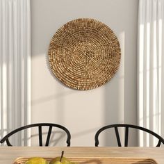 a wooden table topped with two green apples next to a basket filled with pears