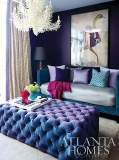 an image of a living room with purple and blue colors on the walls, couches and chandelier