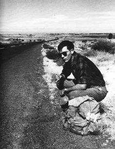 a man kneeling down on the side of a road