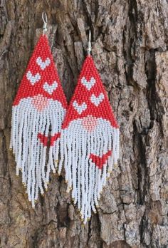 two red and white earrings hanging from a tree