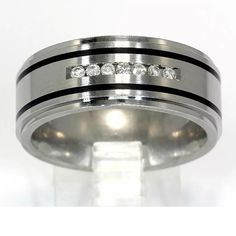 a wedding ring with three diamonds on the side and black inlays, set against a white background