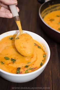 a spoonful of soup is being lifted from a bowl