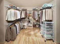 a walk in closet filled with lots of clothes and shoes on shelves next to a wooden floor