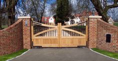 a gated driveway with brick walls and wooden gates