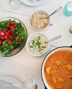 a table topped with bowls filled with different types of food next to plates and utensils