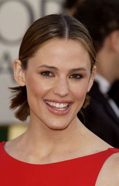 a woman in a red dress smiling at the camera