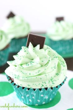 cupcakes with white frosting and green sprinkles