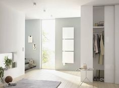 an empty room with white walls and wooden flooring is shown in this image, there are towels hanging on the rack