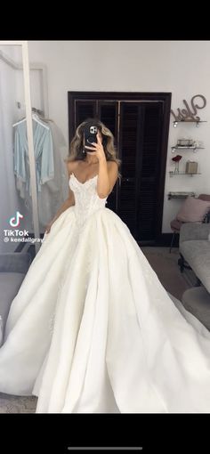 the woman is taking a selfie in her wedding dress while she takes a photo