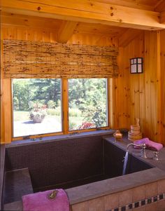 a large jacuzzi tub in the corner of a room with wood paneling